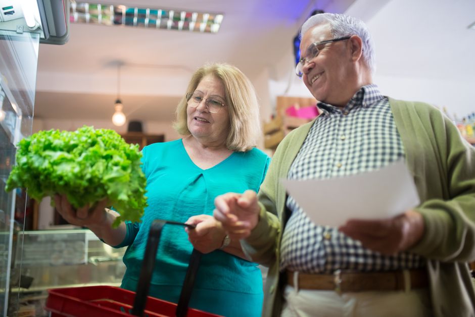 Happy senior couple shopping for fresh vegetables together, enjoying a day out.