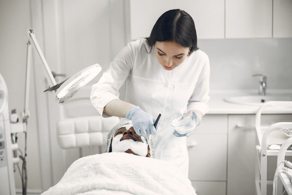 Woman provides facial treatment to patient in a spa setting, ensuring relaxation and care.